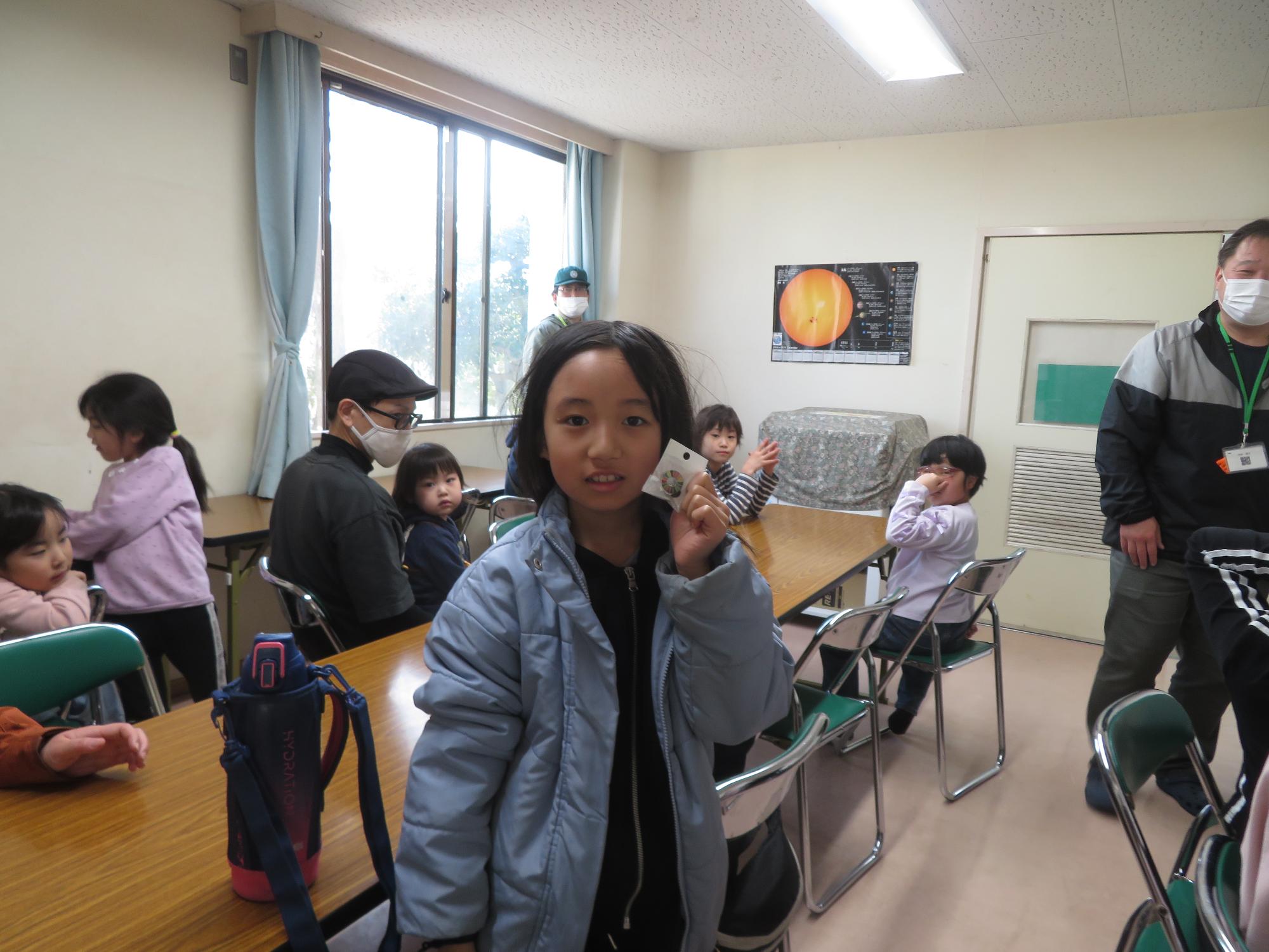 SDGSバッチを持ってポーズしている写真