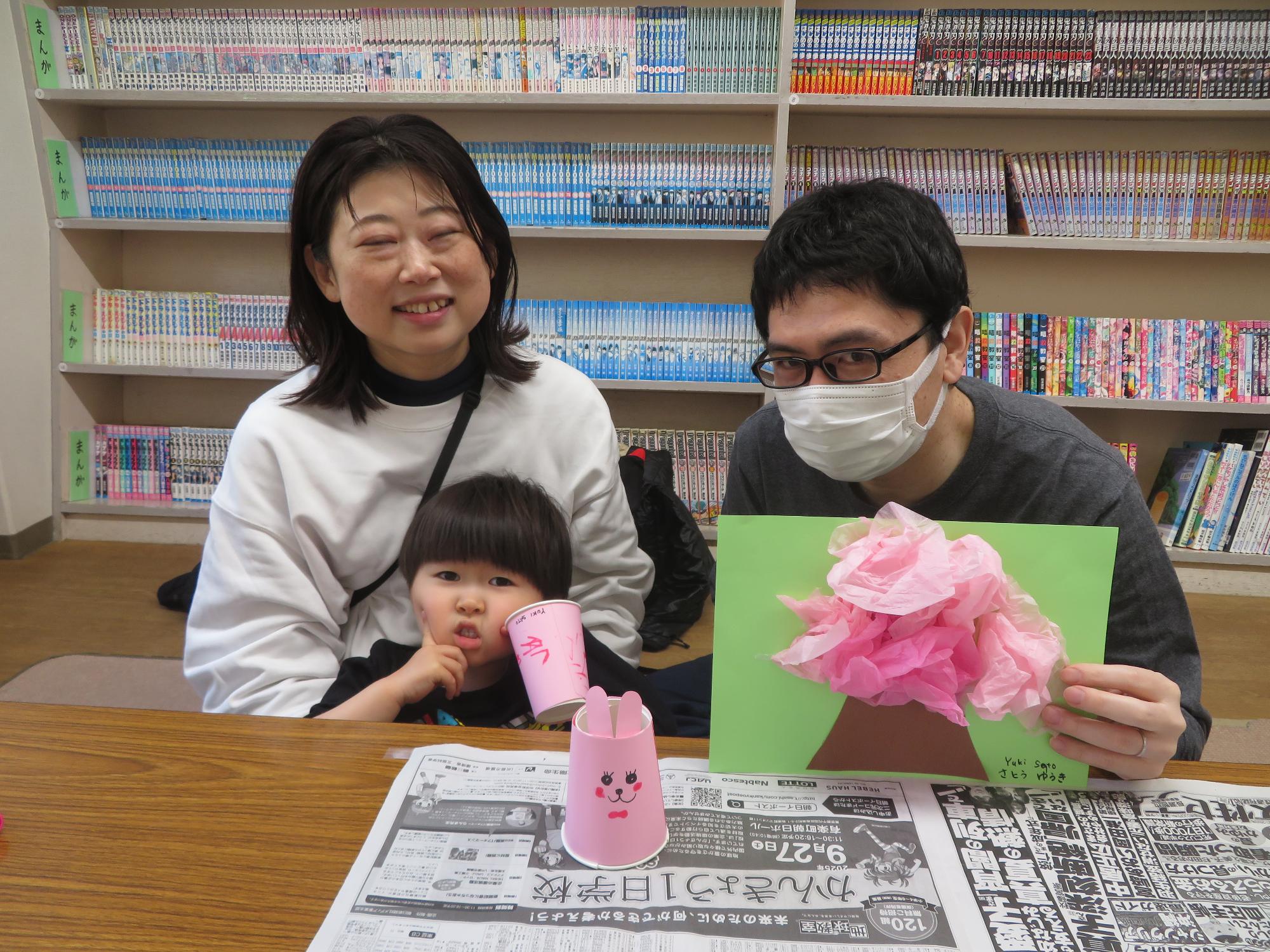 完成した、工作を持ってポーズしている幼児親子の写真