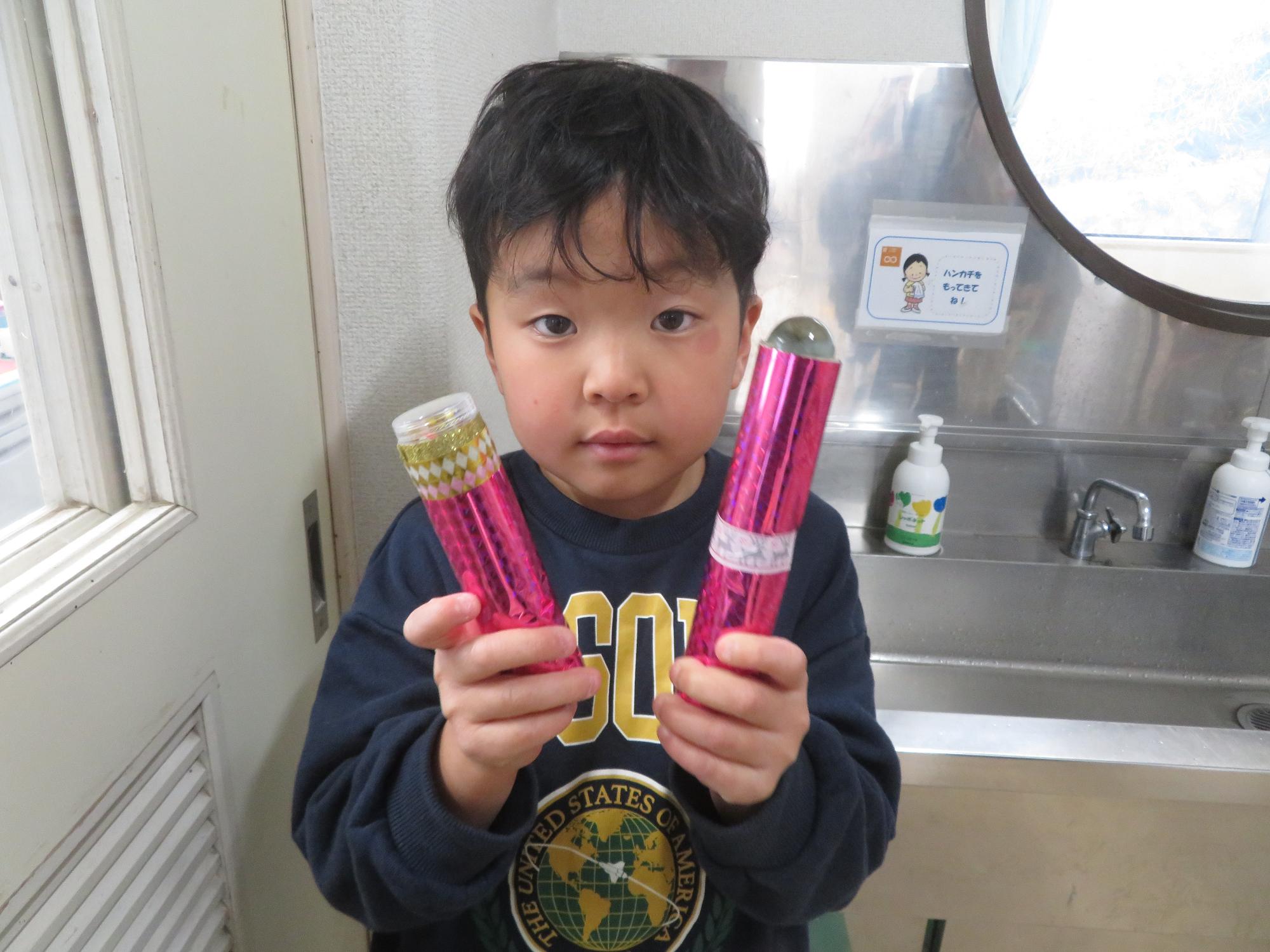 完成した万華鏡を持ってポーズしている幼児の写真