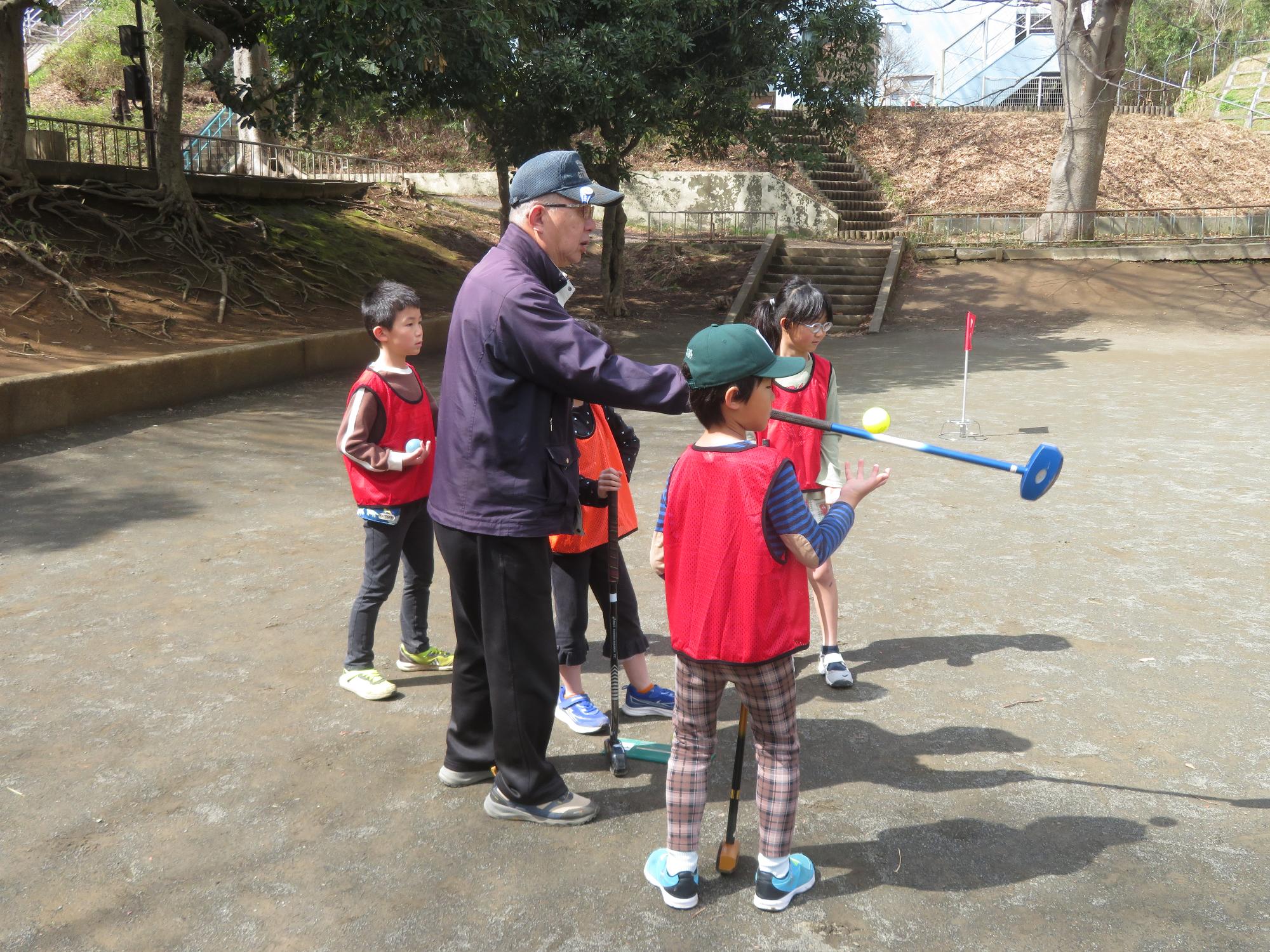 講師が小学生に打ち方を教えている写真