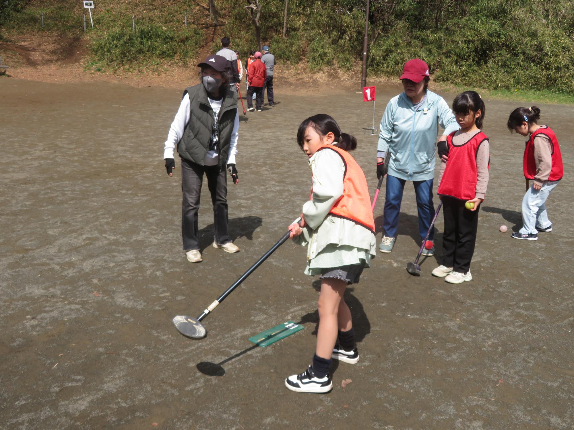 講師が小学生に打ち方を教えている写真