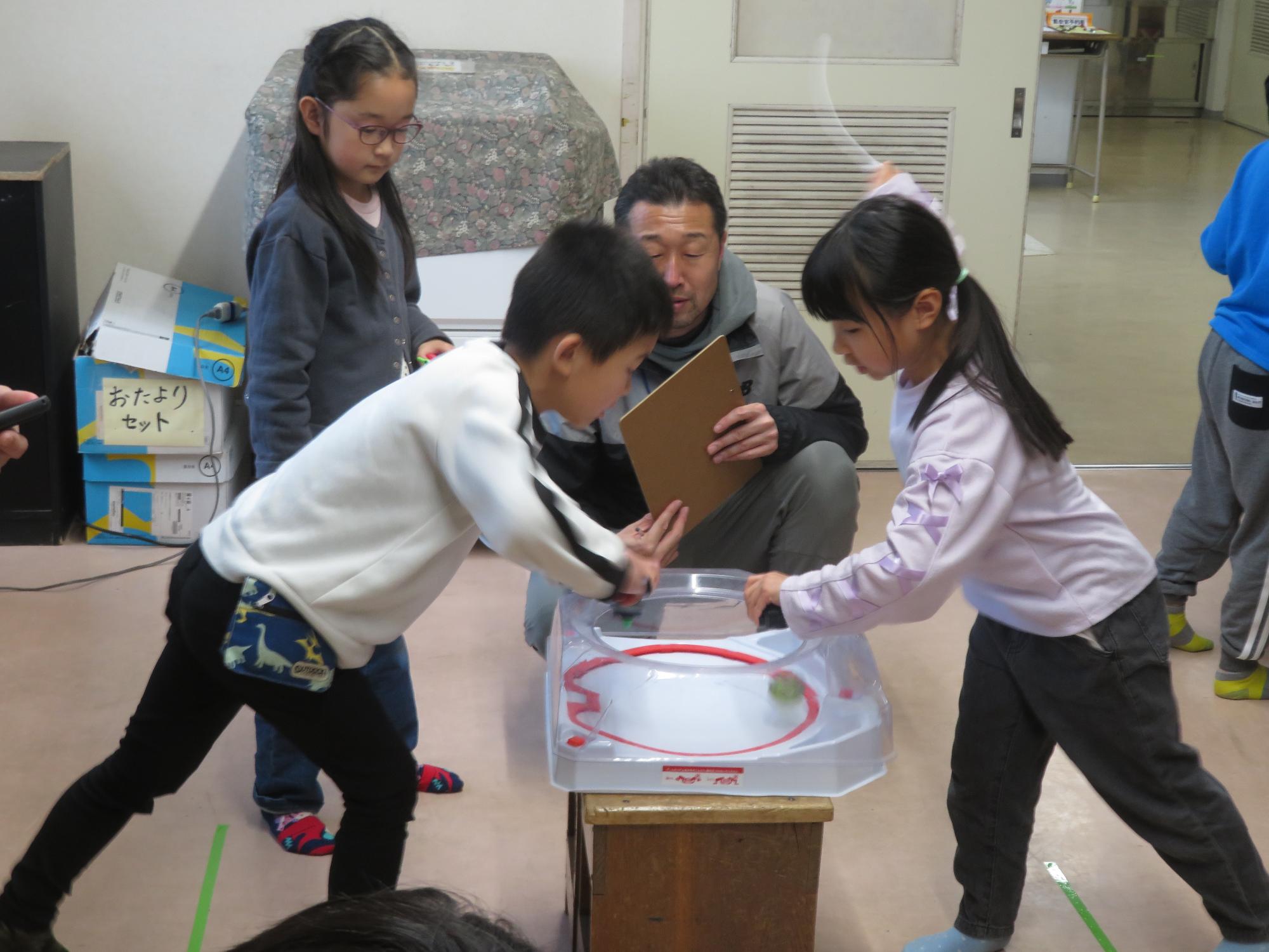 ベイブレード対戦をしている小学生2人の写真