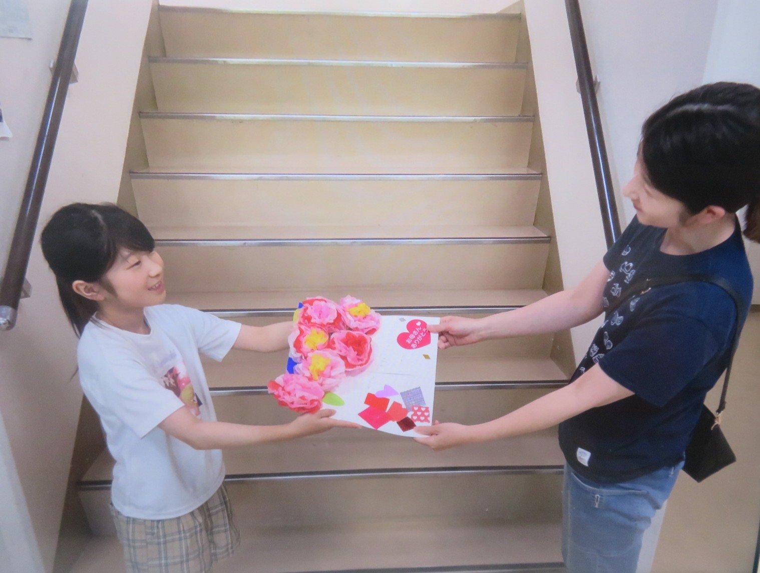 お母さんありがとうとカーネーションの作品を渡す様子