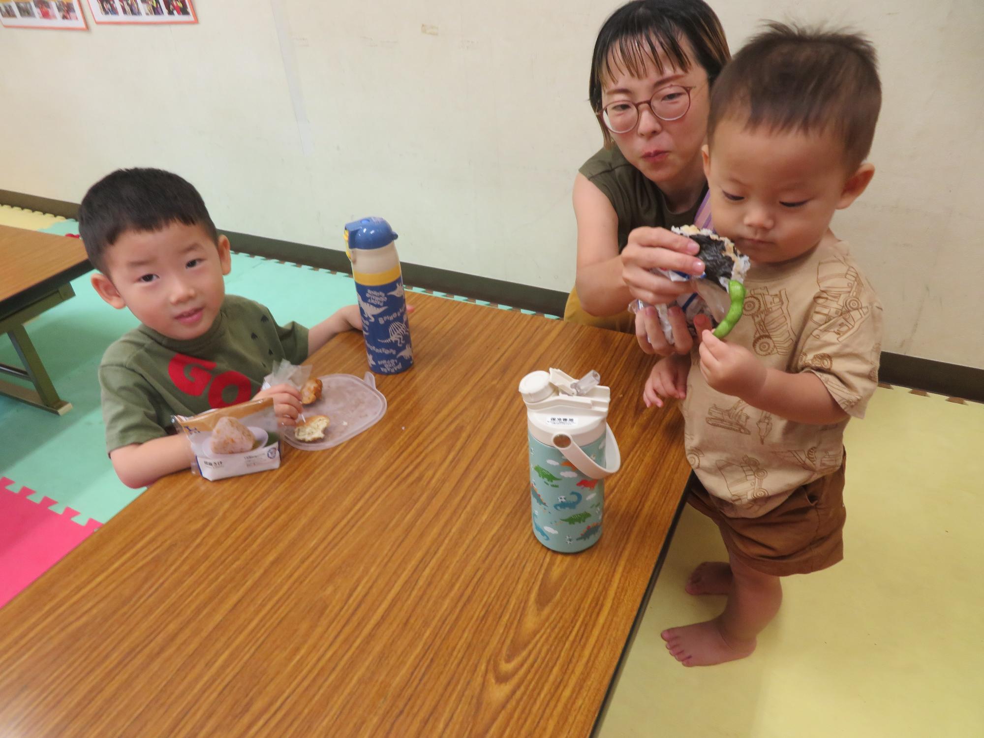 ローソンのおにぎりを幼児親子が美味しく食べている写真