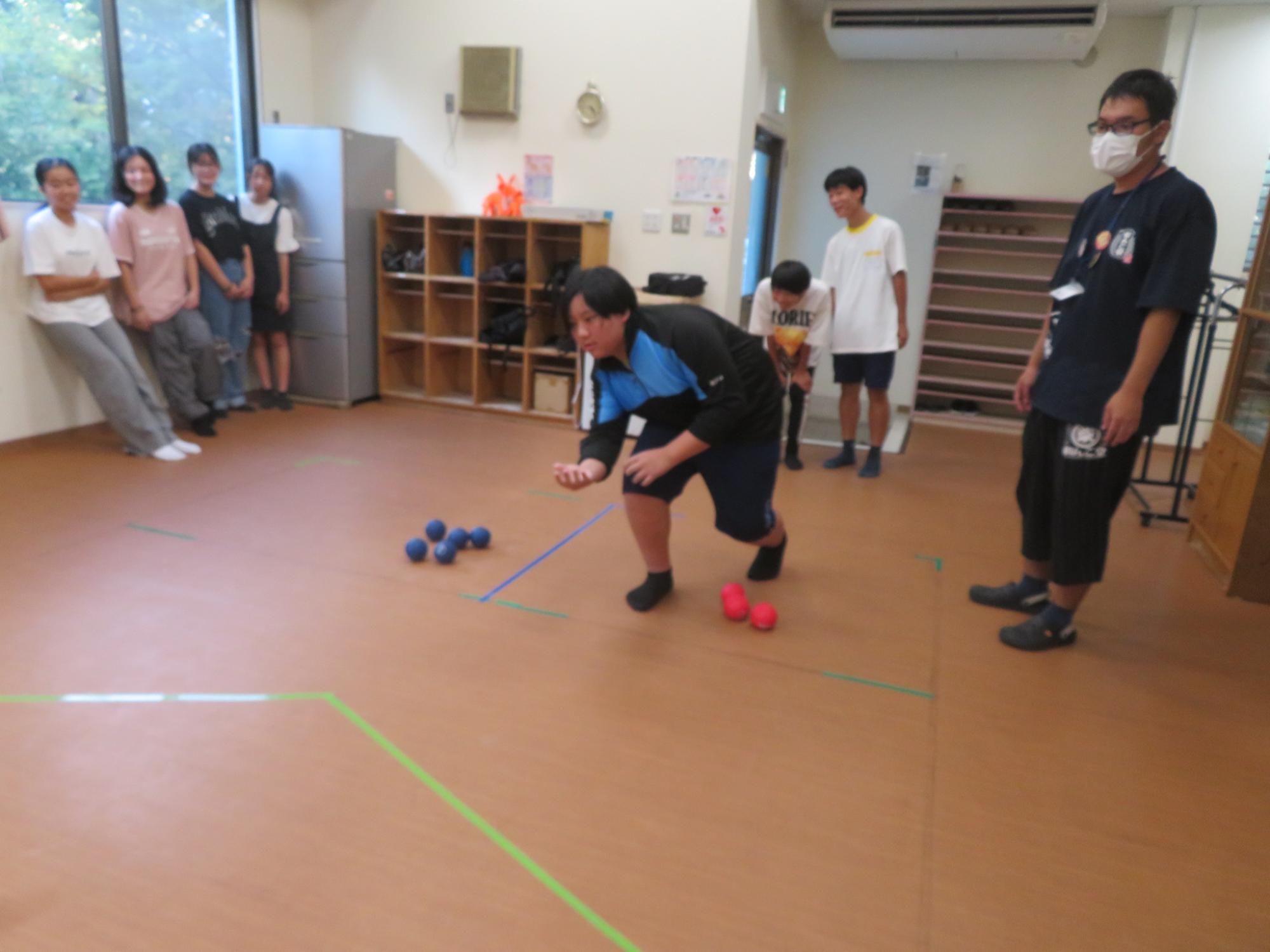 中学生男子がボッチャのボールを投げる写真