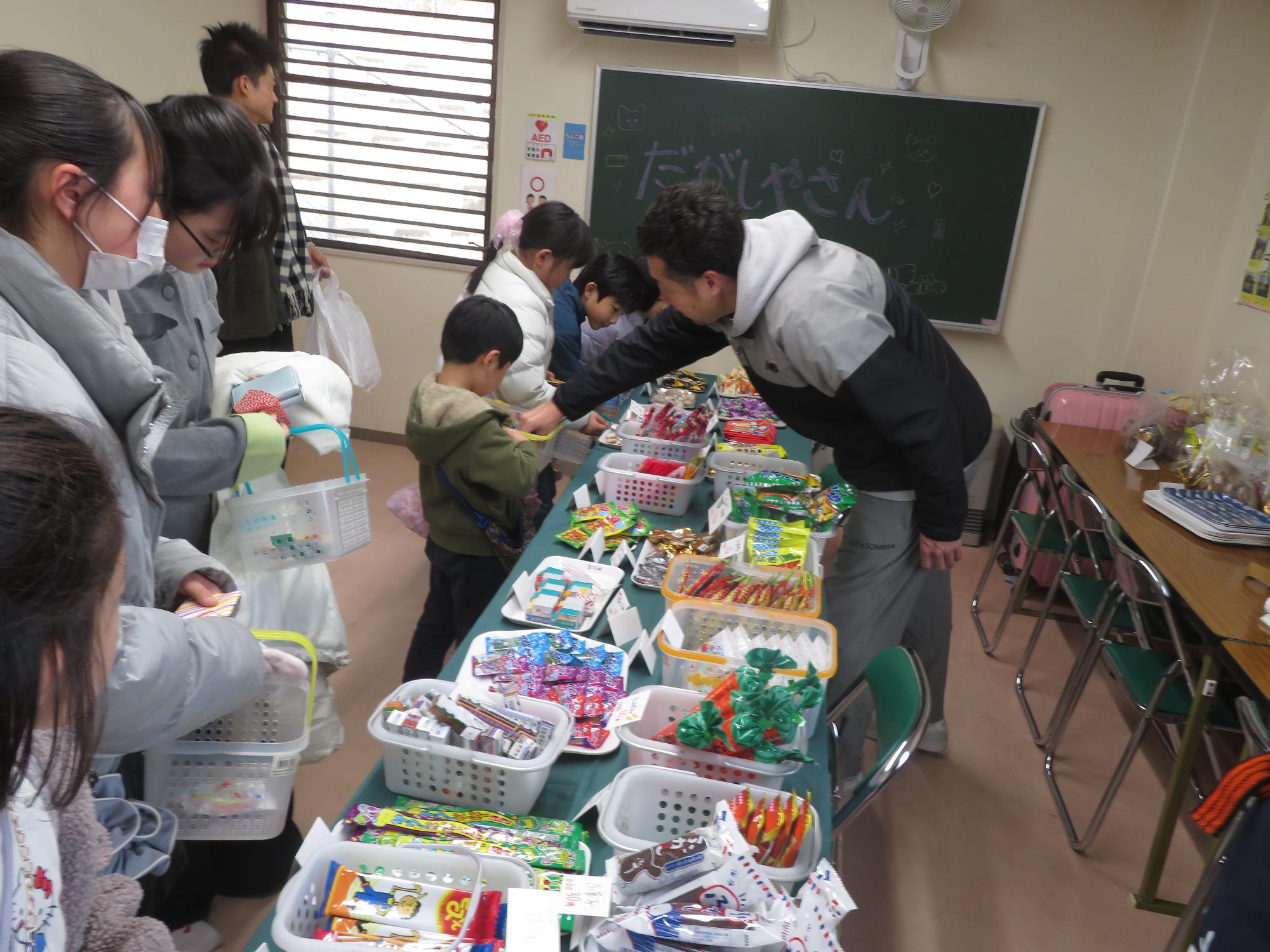 館長と駄菓子を数える男の子の写真