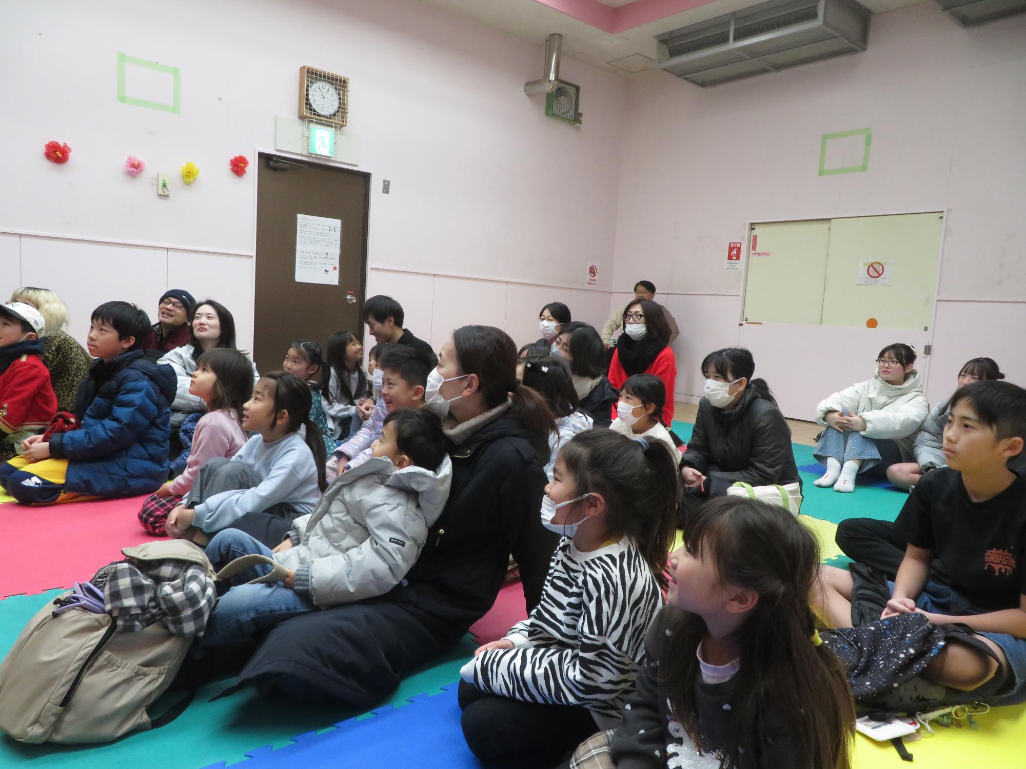 マジックを真剣に見ている参加者の写真