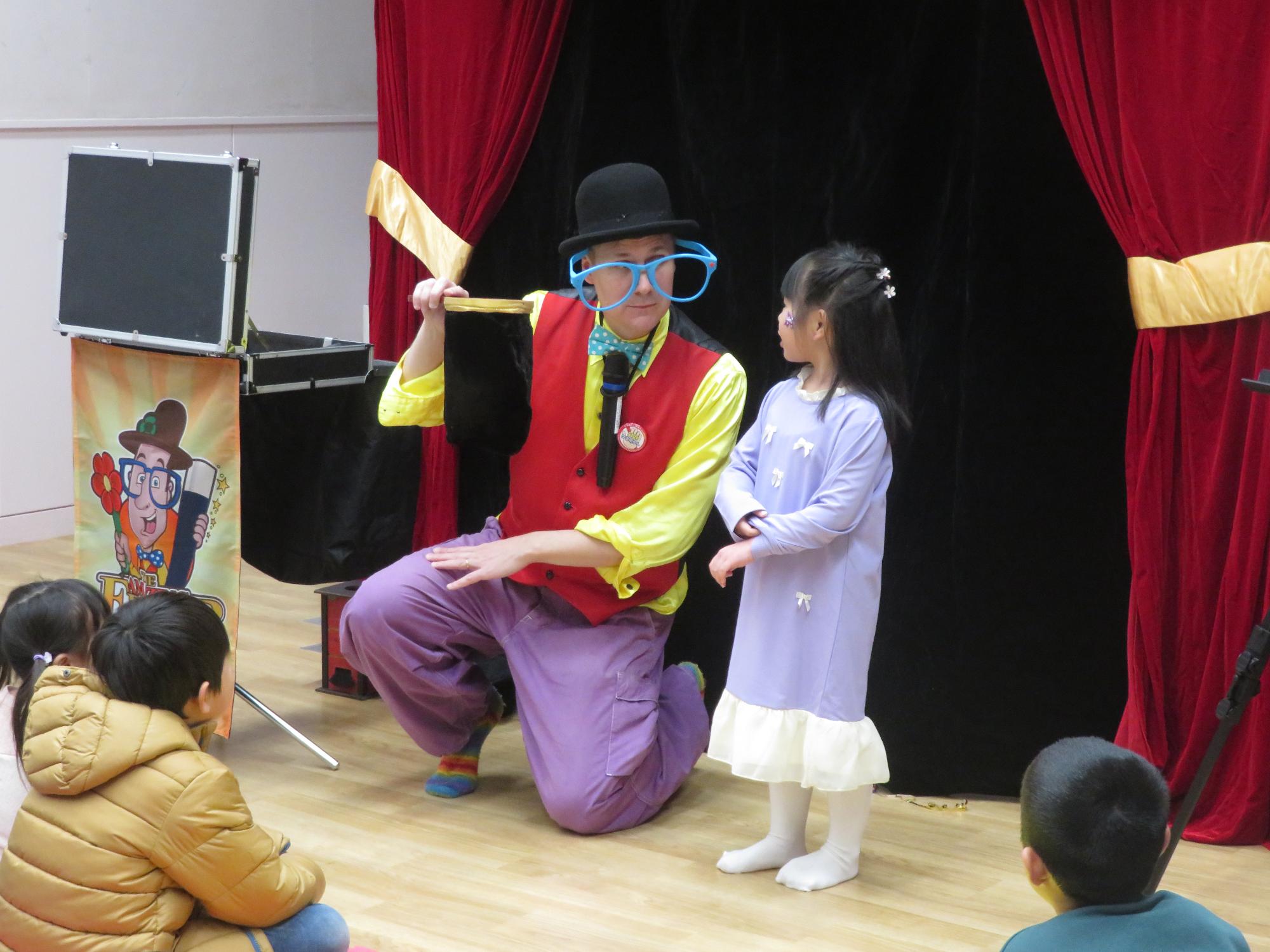 マジシャンと少女がマジックをしている写真