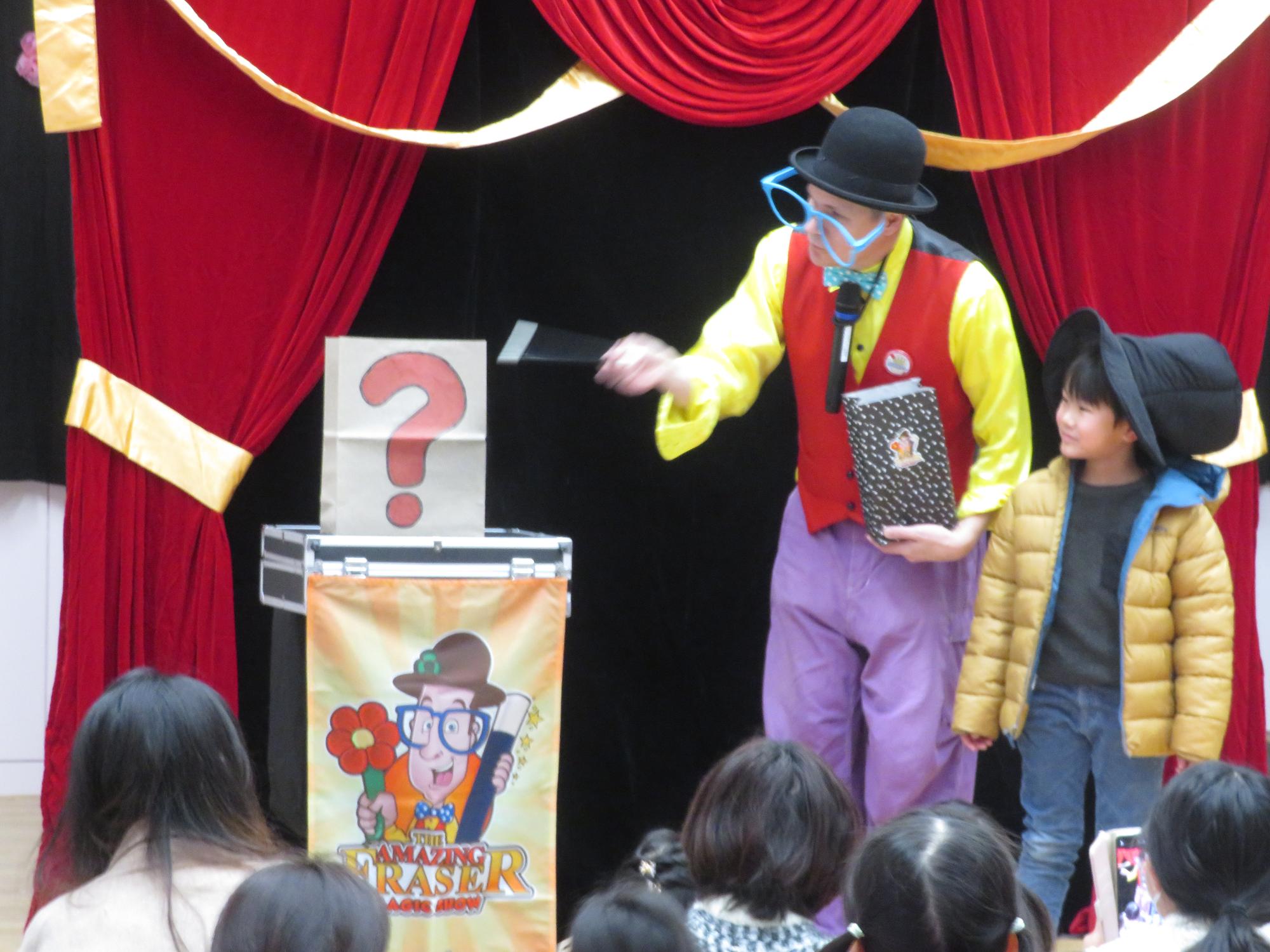 マジシャンと男の子が紙袋に魔法をかけている写真