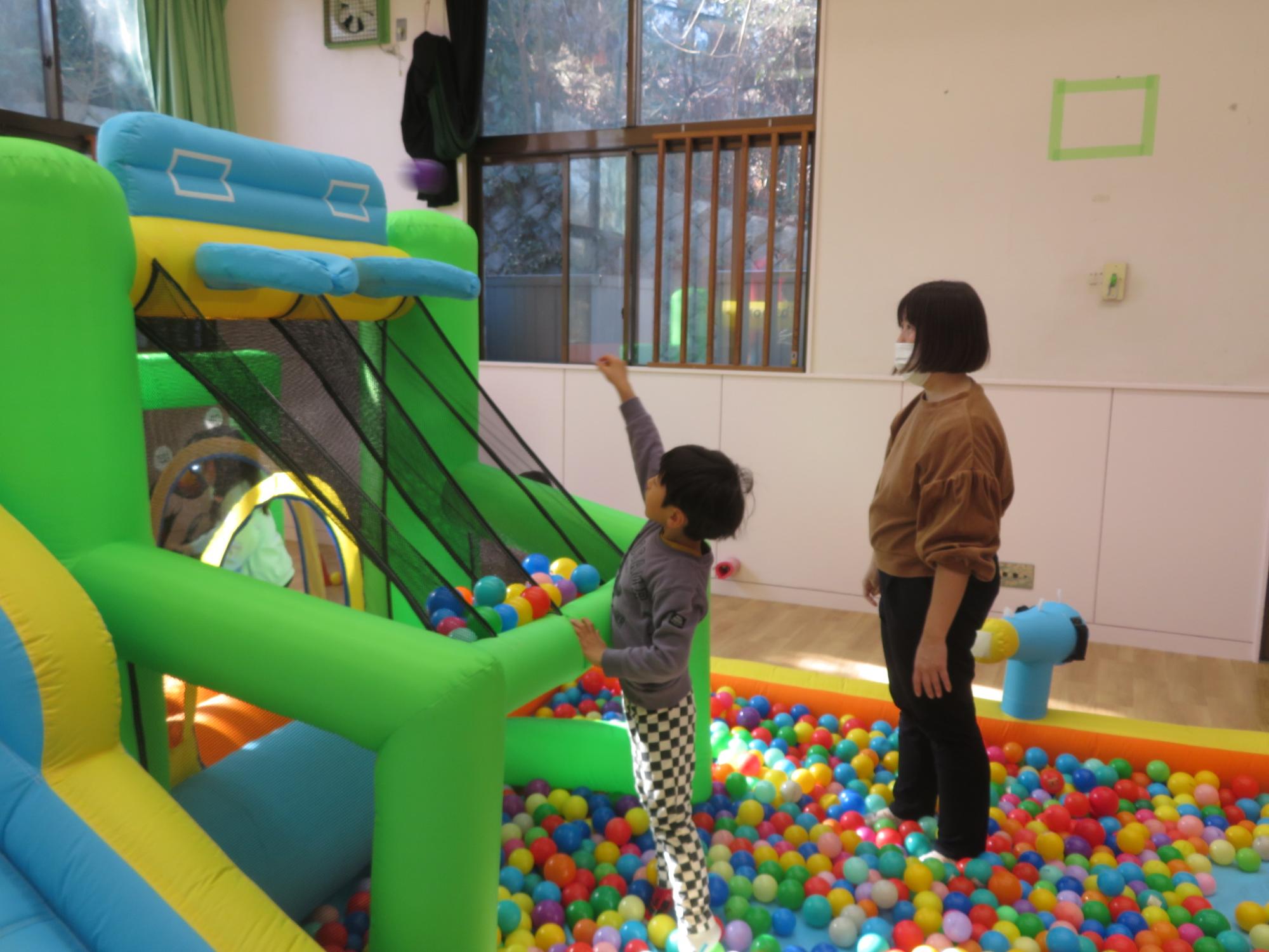 ボールをゴールに向かって投げる幼児と保護者の写真