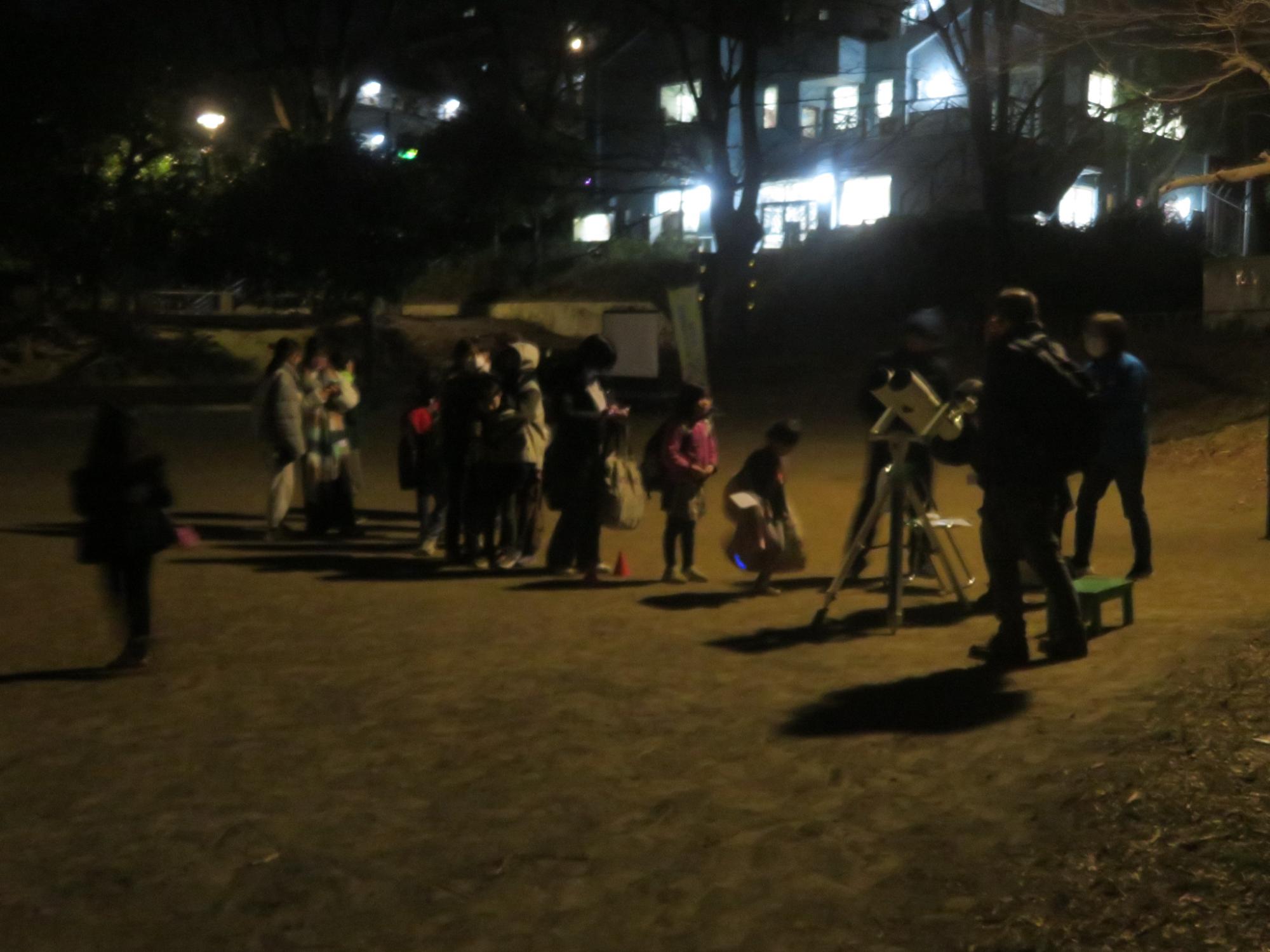 天体望遠鏡を覗く順番を待つ参加者の写真