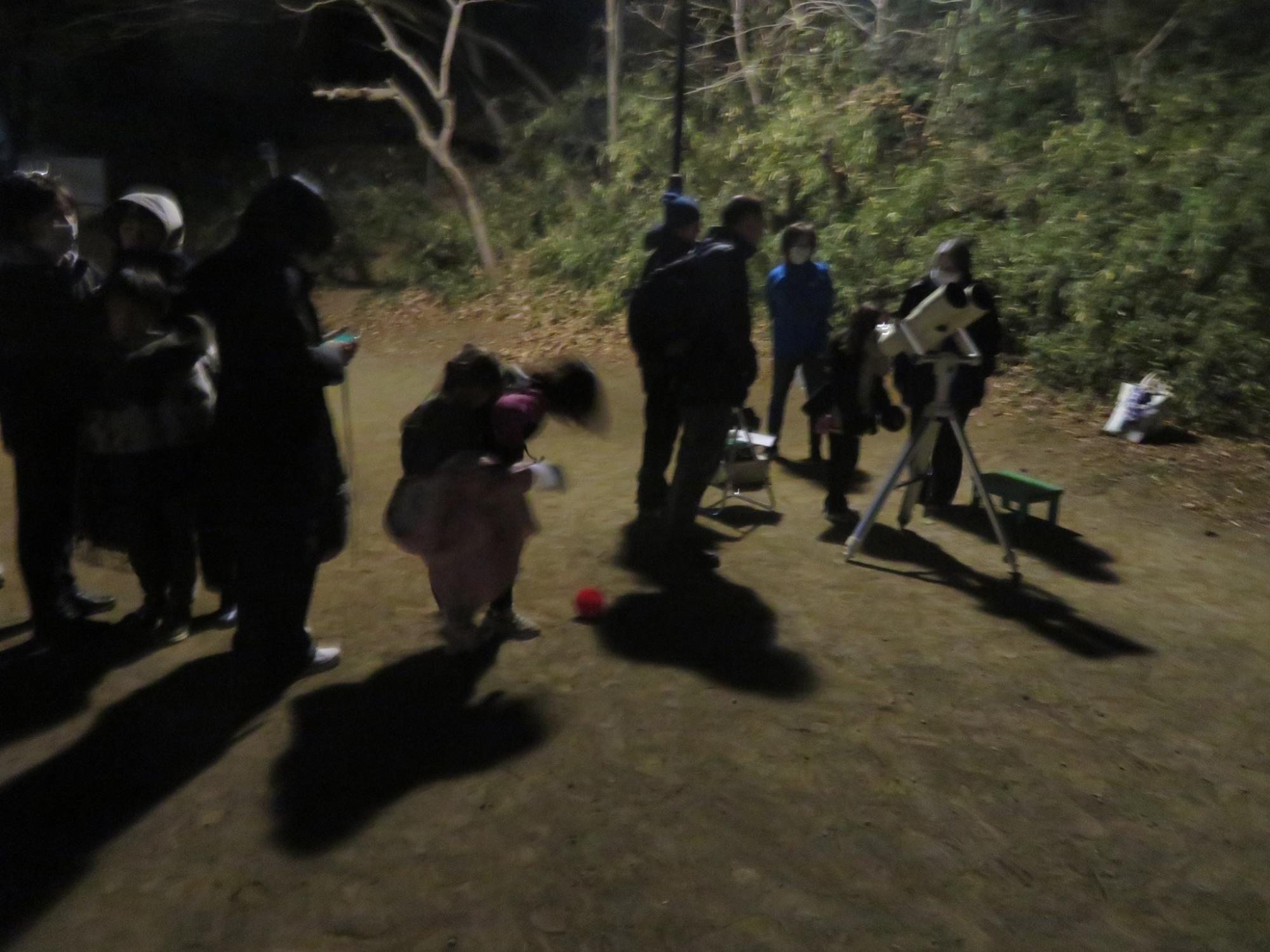 天体望遠鏡で星を観察する児童の写真