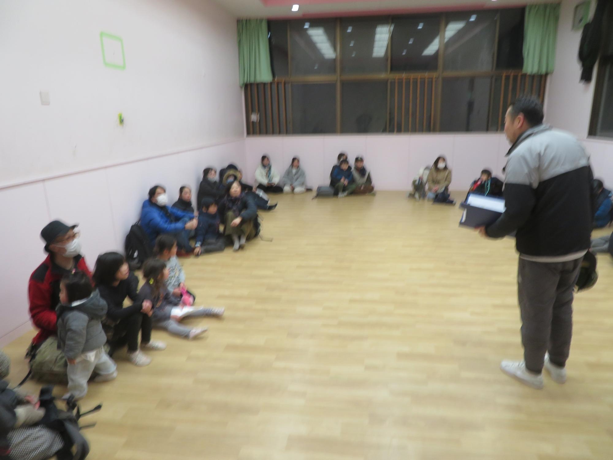 館長から行事の説明を聞く保護者の写真