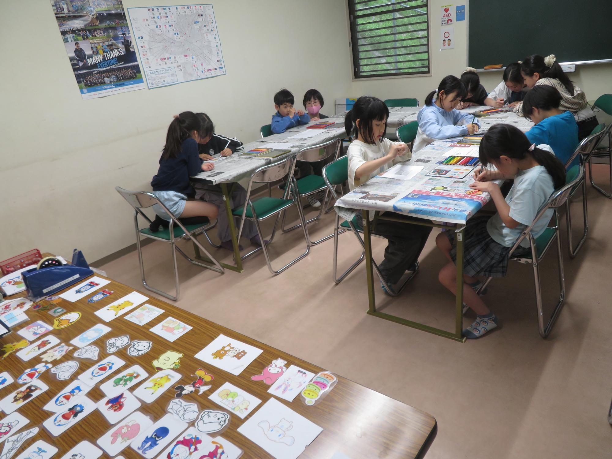 プラバンに絵をかいている小学生11人の写真