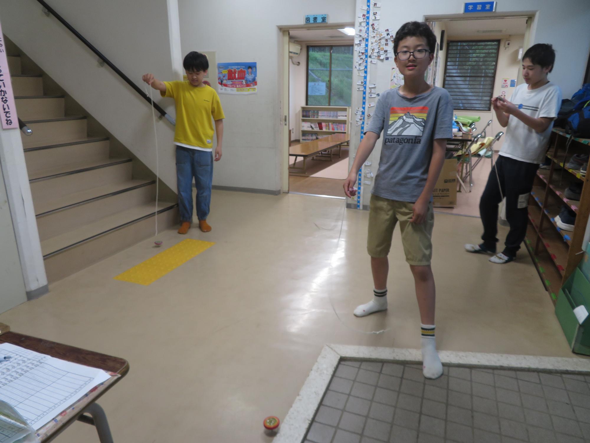 コマ回し名人のスタッフから小学生も中学生もコマ回しを教わりました。