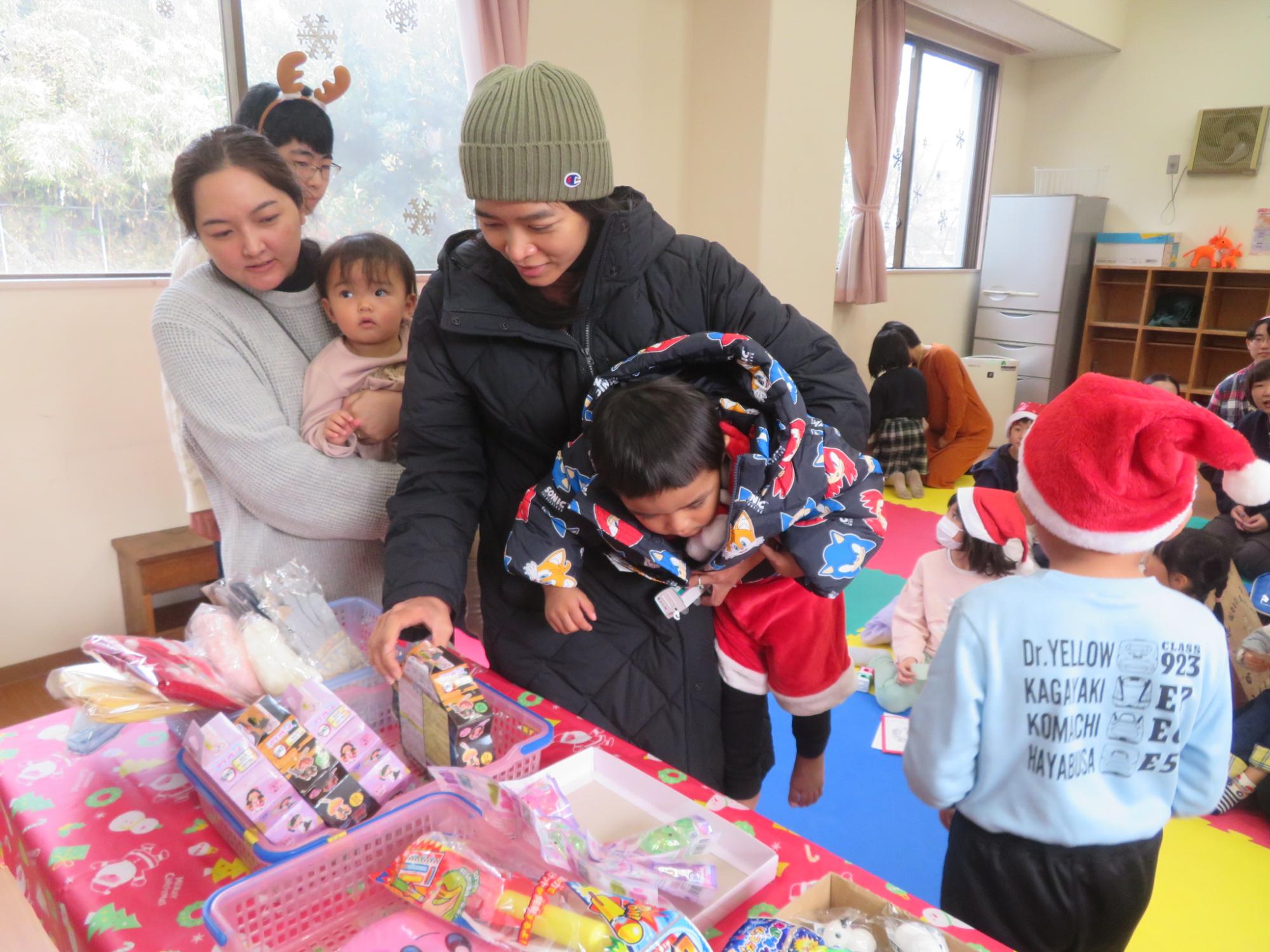 幼児親子が楽しそうにくじびきの景品を選ぶ写真