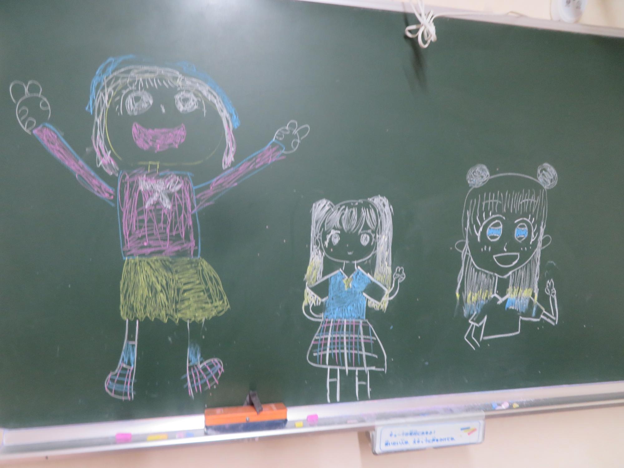 黒板に3人の女の子を描いた写真